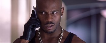 Movie still from “Cradle 2 the Grave” (2003), directed by Andrzej Bartkowiak – A man with a beard is talking on a cell phone; Close Up shot, Low angle