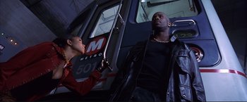 Movie still from “Cradle 2 the Grave” (2003), directed by Andrzej Bartkowiak – A man and a woman on a subway train; Medium shot, Low angle