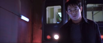 Movie still from “Cradle 2 the Grave” (2003), directed by Andrzej Bartkowiak – A man standing in front of a train at night; Close Up shot, Low angle