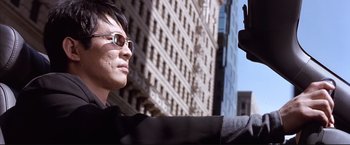 Movie still from “Cradle 2 the Grave” (2003), directed by Andrzej Bartkowiak – A man in a black jacket and sunglasses is looking at a man in a black jacket and sunglasses; Close Up shot, Low angle