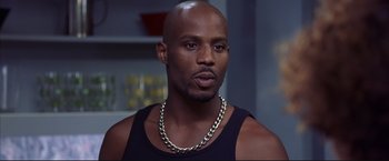 Movie still from “Cradle 2 the Grave” (2003), directed by Andrzej Bartkowiak – A bald man with a gold chain around his neck; Close Up shot, Low angle