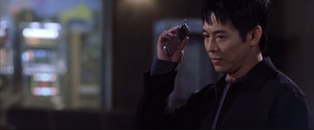 Movie still from “Cradle 2 the Grave” (2003), directed by Andrzej Bartkowiak – A man holding up a cell phone to take a picture; Close Up shot, Low angle