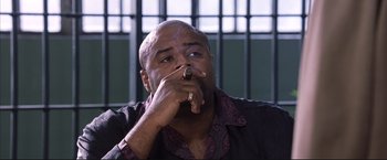 Movie still from “Cradle 2 the Grave” (2003), directed by Andrzej Bartkowiak – A bald man smoking a cigarette in front of a jail cell; Close Up shot, Low angle