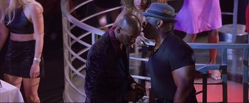 Movie still from “Cradle 2 the Grave” (2003), directed by Andrzej Bartkowiak – Two men standing next to each other on a stage; Medium shot, Over the shoulder angle