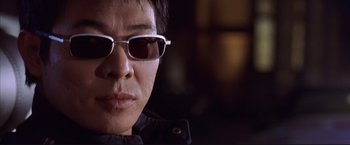 Movie still from “Cradle 2 the Grave” (2003), directed by Andrzej Bartkowiak – A person wearing sunglasses; Close Up shot, Low angle