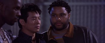 Movie still from “Cradle 2 the Grave” (2003), directed by Andrzej Bartkowiak – Two men standing next to each other in front of a building; Close Up shot, Low angle