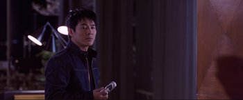 Movie still from “Cradle 2 the Grave” (2003), directed by Andrzej Bartkowiak – A man holding a remote control in his hand; Close Up shot, Over the shoulder angle