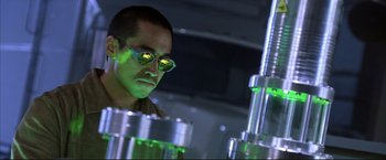 Movie still from “Cradle 2 the Grave” (2003), directed by Andrzej Bartkowiak – A man wearing glasses looking at some green lights; Medium shot, Low angle