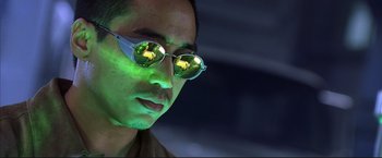 Movie still from “Cradle 2 the Grave” (2003), directed by Andrzej Bartkowiak – A person wearing a pair of sunglasses; Close Up shot, Low angle