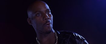 Movie still from “Cradle 2 the Grave” (2003), directed by Andrzej Bartkowiak – A person wearing a necklace; Close Up shot, Low angle