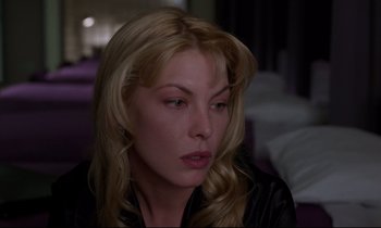 Movie still from “Crash” (1996), directed by David Cronenberg – A woman with long blonde hair wearing a leather jacket; Close Up shot, Over the shoulder angle