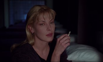 Movie still from “Crash” (1996), directed by David Cronenberg – A beautiful woman holding a cigarette in her hand; Close Up shot, Over the shoulder angle
