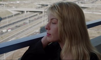 Movie still from “Crash” (1996), directed by David Cronenberg – A beautiful blond woman sitting on top of a building; Close Up shot, High angle