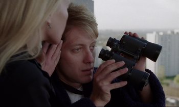 Movie still from “Crash” (1996), directed by David Cronenberg – A man and a woman looking at a pair of binoculars; Close Up shot, Over the shoulder angle
