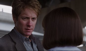 Movie still from “Crash” (1996), directed by David Cronenberg – A man and a woman are talking to each other; Close Up shot, Over the shoulder angle