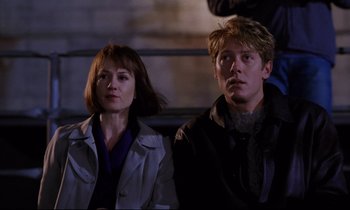 Movie still from “Crash” (1996), directed by David Cronenberg – A man and a woman sitting next to each other; Medium shot, Over the shoulder angle