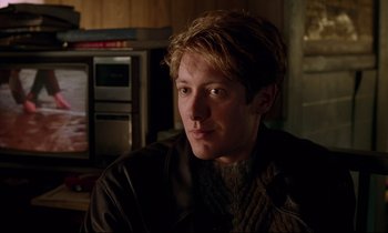 Movie still from “Crash” (1996), directed by David Cronenberg – A young man sitting in front of an oven in a kitchen; Close Up shot, Over the shoulder angle