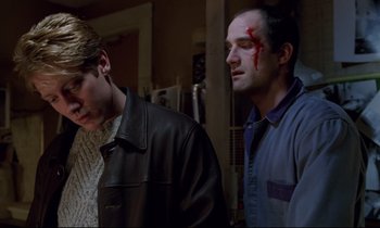 Movie still from “Crash” (1996), directed by David Cronenberg – Two men with blood on their faces and one has a cut on his head; Medium shot, Low angle