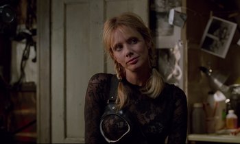 Movie still from “Crash” (1996), directed by David Cronenberg – A woman in a see through shirt holding a leather strap; Close Up shot, Over the shoulder angle