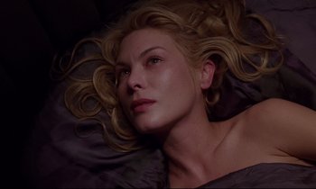 Movie still from “Crash” (1996), directed by David Cronenberg – A woman laying on the ground with her eyes closed; Close Up shot, Overhead angle