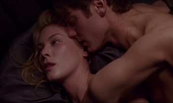 Movie still from “Crash” (1996), directed by David Cronenberg – A man and a woman laying in bed together; Close Up shot, Overhead angle