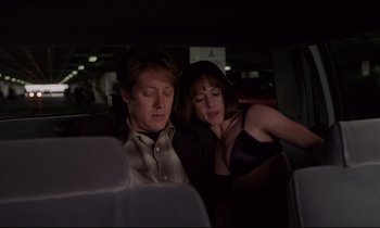 Movie still from “Crash” (1996), directed by David Cronenberg – A man and a woman sitting in the back of a car; Medium shot, High angle