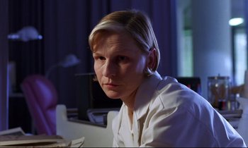 Movie still from “Crash” (1996), directed by David Cronenberg – A woman sitting in front of a computer monitor; Close Up shot, Low angle