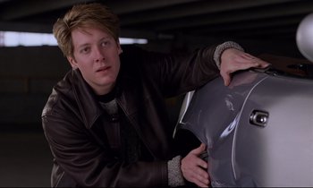 Movie still from “Crash” (1996), directed by David Cronenberg – A man in a leather jacket holding an umbrella; Close Up shot, Low angle