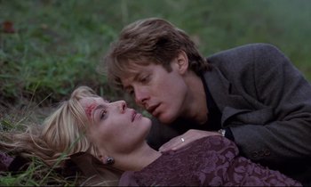 Movie still from “Crash” (1996), directed by David Cronenberg – A man and a woman laying in the grass; Close Up shot, Low angle
