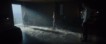 Movie still from “The Girl in the Spider's Web” (2018), directed by Fede Alvarez – A girl is standing in the dark in a room; Wide shot, High angle