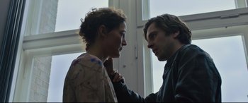 Movie still from “The Girl in the Spider's Web” (2018), directed by Fede Alvarez – A man and a woman standing next to each other in front of a window; Close Up shot, Over the shoulder angle