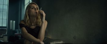Movie still from “The Girl in the Spider's Web” (2018), directed by Fede Alvarez – A woman sitting on a couch smoking a cigarette; Close Up shot, Low angle