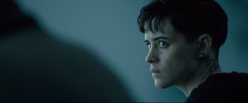 Movie still from “The Girl in the Spider's Web” (2018), directed by Fede Alvarez – A person with short black hair; Close Up shot, Over the shoulder angle