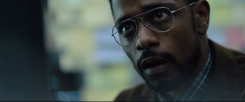 Movie still from “The Girl in the Spider's Web” (2018), directed by Fede Alvarez – A person wearing a pair of eyeglasses; Close Up shot, Over the shoulder angle