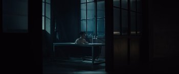 Movie still from “The Girl in the Spider's Web” (2018), directed by Fede Alvarez – A man sitting in a bath tub in a dark room; Wide shot, High angle