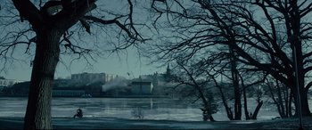 Movie still from “The Girl in the Spider's Web” (2018), directed by Fede Alvarez – A view of a lake and a city in the distance; Extreme Wide shot, High angle