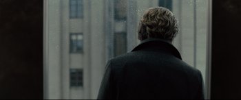 Movie still from “The Girl in the Spider's Web” (2018), directed by Fede Alvarez – A man standing in front of a window looking outside; Close Up shot, Over the shoulder angle