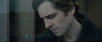 Movie still from “The Girl in the Spider's Web” (2018), directed by Fede Alvarez – A man's face as he looks down; Close Up shot, Over the shoulder angle