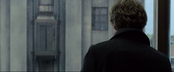 Movie still from “The Girl in the Spider's Web” (2018), directed by Fede Alvarez – A man standing in front of a window looking outside; Close Up shot, Over the shoulder angle