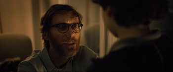 Movie still from “The Girl in the Spider's Web” (2018), directed by Fede Alvarez – A man with a goatee and glasses talking to a person; Close Up shot, Over the shoulder angle