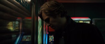 Movie still from “The Girl in the Spider's Web” (2018), directed by Fede Alvarez – A man with long blonde hair looking down at his face; Close Up shot, Low angle