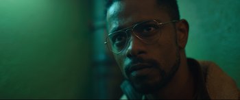 Movie still from “The Girl in the Spider's Web” (2018), directed by Fede Alvarez – A person wearing a pair of eyeglasses; Close Up shot, Low angle