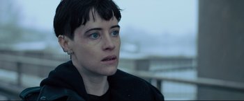 Movie still from “The Girl in the Spider's Web” (2018), directed by Fede Alvarez – A person with short hair; Close Up shot, Over the shoulder angle