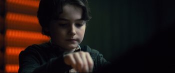 Movie still from “The Girl in the Spider's Web” (2018), directed by Fede Alvarez – A young boy is looking down at his tie; Close Up shot, Over the shoulder angle