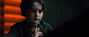 Movie still from “The Girl in the Spider's Web” (2018), directed by Fede Alvarez – A young boy is looking into the camera; Close Up shot, Over the shoulder angle