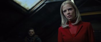 Movie still from “The Girl in the Spider's Web” (2018), directed by Fede Alvarez – A woman in a red dress standing next to a man in a black suit; Close Up shot, Low angle