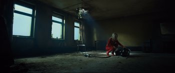 Movie still from “The Girl in the Spider's Web” (2018), directed by Fede Alvarez – A woman kneeling on the ground in a room; Wide shot, Low angle