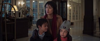 Movie still from “Crazy Rich Asians” (2018), directed by Jon M. Chu – A woman standing next to two young children; Medium shot, Low angle