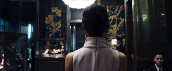Movie still from “Crazy Rich Asians” (2018), directed by Jon M. Chu – A woman in a white dress looking into a mirror; Medium shot, Over the shoulder angle