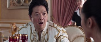 Movie still from “Crazy Rich Asians” (2018), directed by Jon M. Chu – An older asian man with a surprised look on his face; Close Up shot, Over the shoulder angle